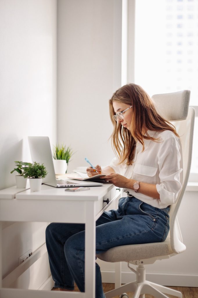 Working young girl in casual clothes with laptop at home office. Online education, online work