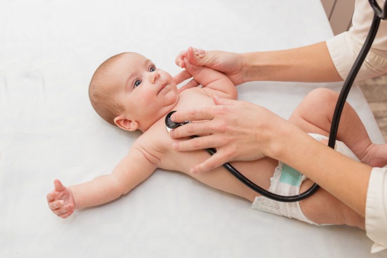 Pediatrician listens to newborn. physical examination of a small child